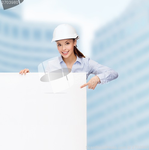 Image of businesswoman in helmet pointing finger to board