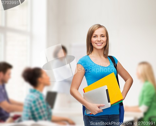 Image of smiling student with bag, folders and tablet pc