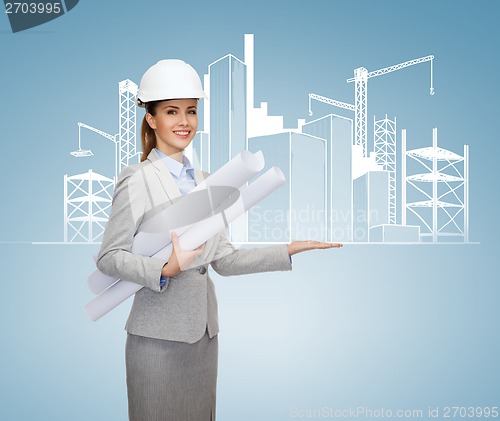 Image of smiling architect in white helmet with blueprints