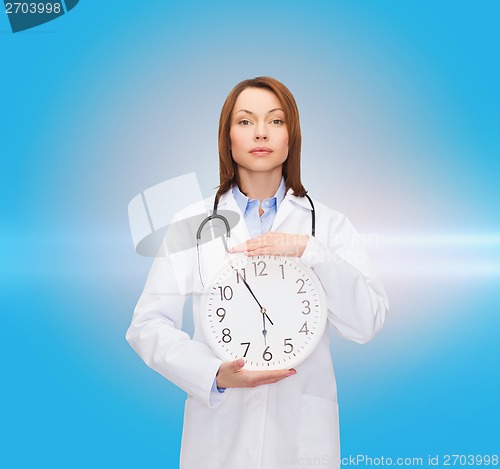 Image of calm female doctor with wall clock