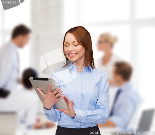 Image of smiling woman looking at tablet pc at office