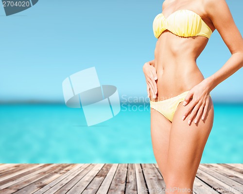 Image of closeup of female body in bikini at beach