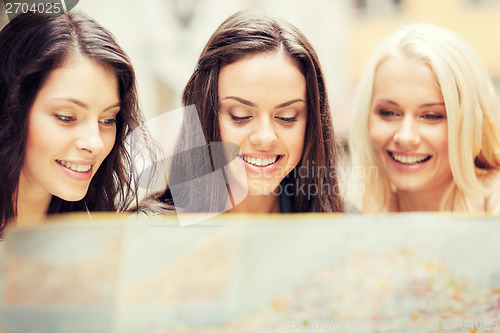 Image of beautiful girls looking into tourist map in city