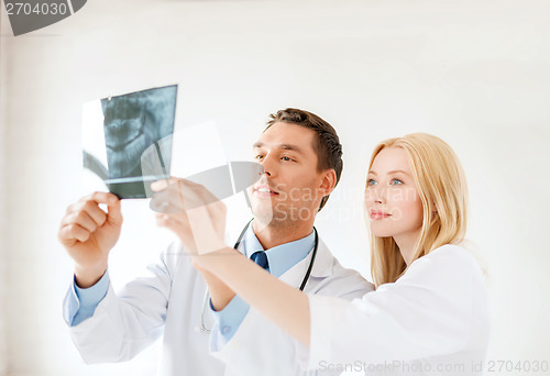 Image of smiling male doctor or dentist looking at x-ray