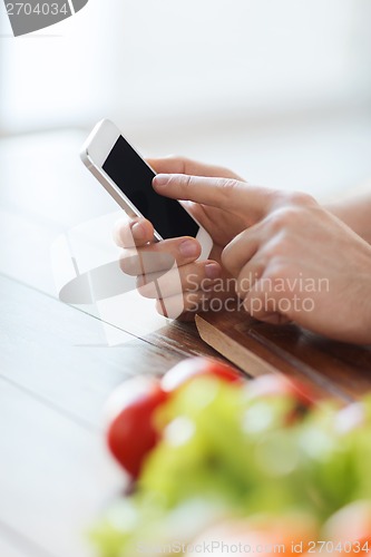 Image of closeup of male hand pointing finger to smartphone