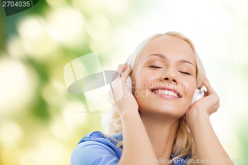 Image of smiling young girl in headphones outdoors