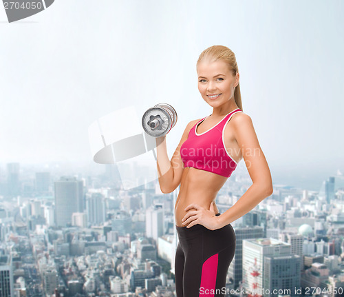 Image of smiling woman with heavy steel dumbbell