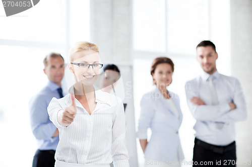 Image of businesswoman in office showign thumbs up