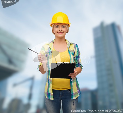 Image of smiling woman in helmet with clipboard