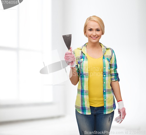 Image of smiling female worker in gloves with spatula