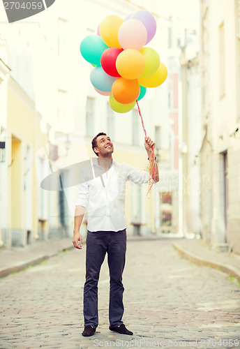 Image of man with colorful balloons in the city