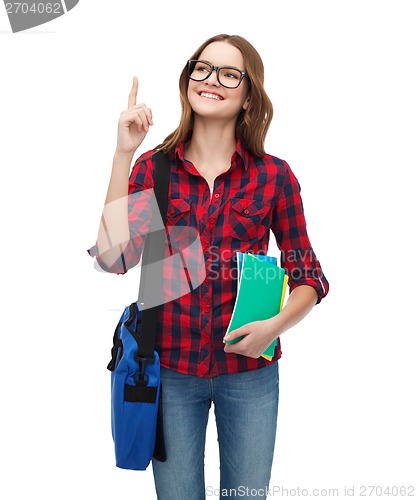 Image of smiling female student with bag and notebooks