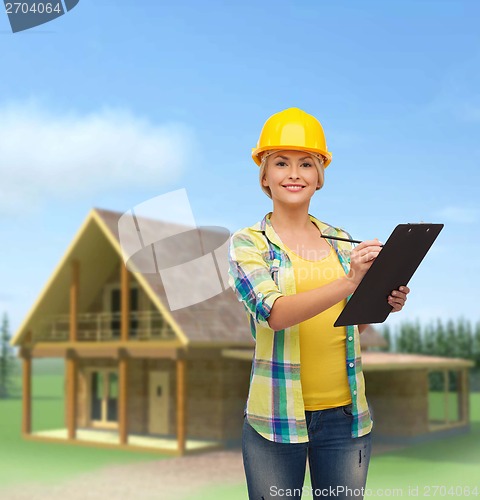 Image of smiling woman in helmet with clipboard
