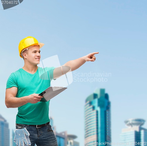 Image of smiling man in helmet with clipboard