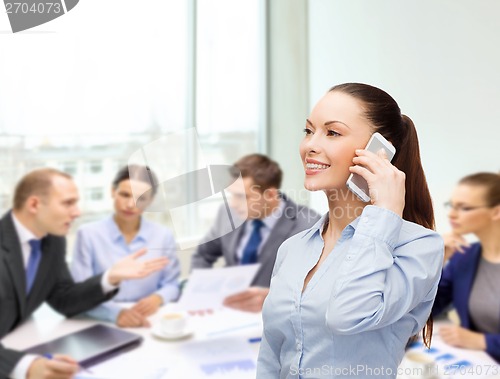 Image of young smiling businesswoman with smartphone