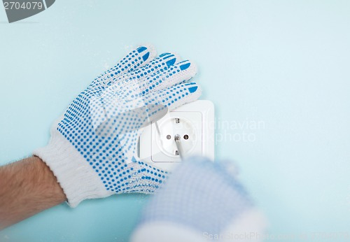 Image of close up of male in gloves installing new socket