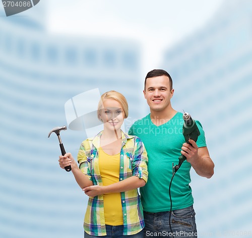 Image of smiling couple with hammer and drill