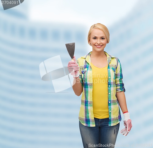 Image of smiling female worker in gloves with spatula