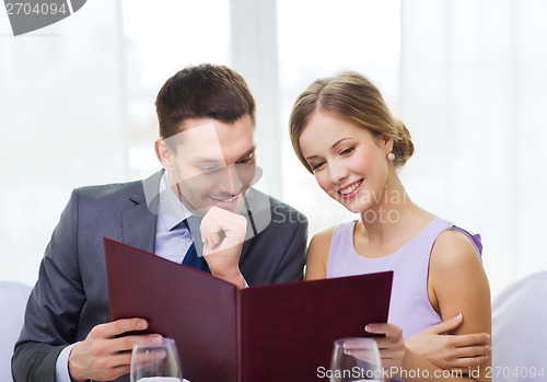 Image of smiling couple with menu at restaurant