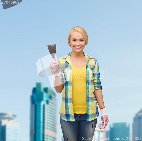 Image of smiling female worker in gloves with spatula