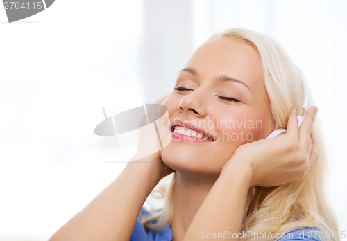 Image of smiling young girl in headphones at home