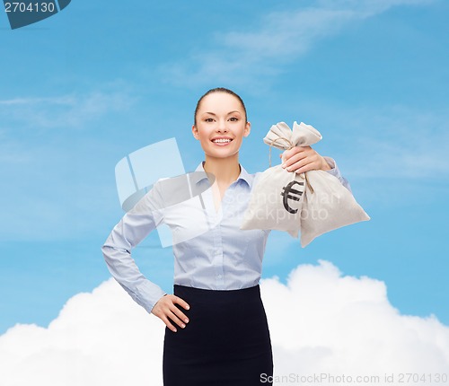 Image of young businesswoman holding money bags with euro