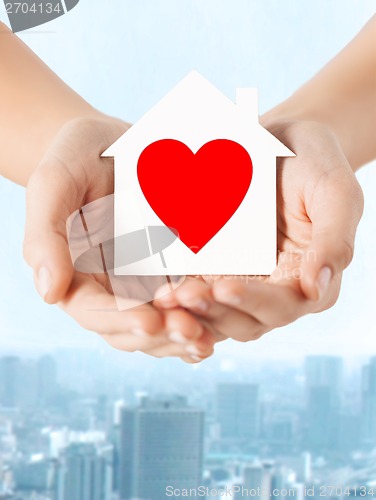 Image of hands holding white paper house