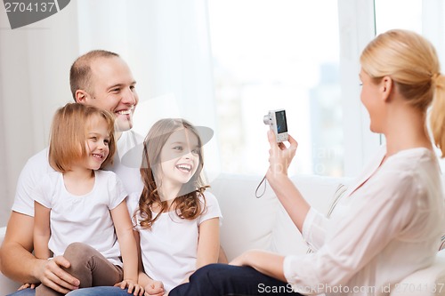 Image of mother taking picture of father and daughters