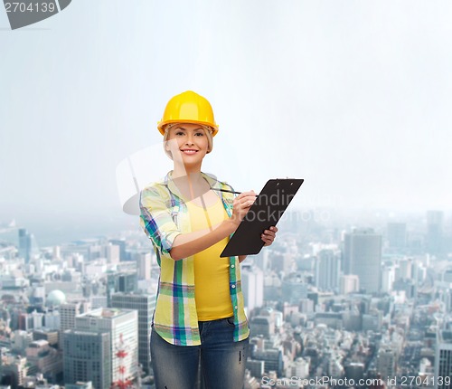 Image of smiling woman in helmet with clipboard