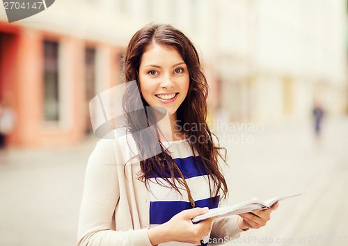 Image of girl looking into tourist book in the city