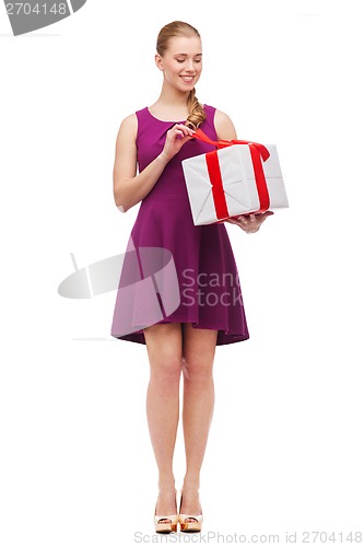 Image of wondering smiling girl with present box