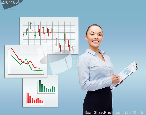 Image of young smiling businesswoman with clipboard and pen