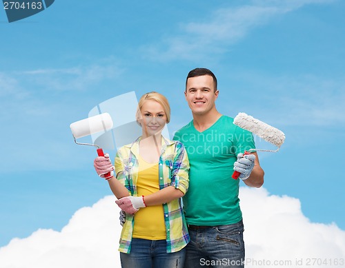 Image of smiling couple in gloves with paint rollers