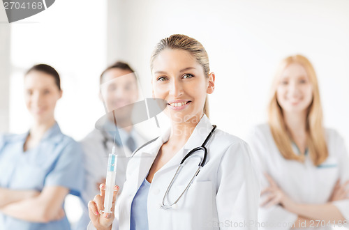 Image of female doctor holding syringe with injection