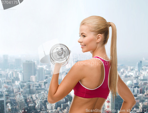 Image of smiling woman with heavy steel dumbbell