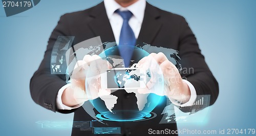 Image of businessman showing smartphone with globe hologram