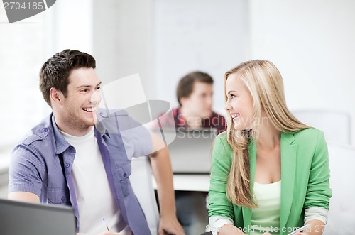 Image of smiling students looking at each other at school