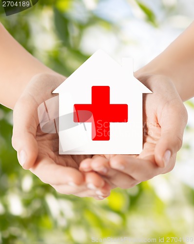 Image of hands holding paper house with red cross