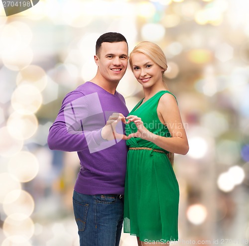 Image of smiling couple showing heart with hands