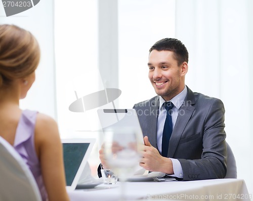 Image of man with tablet pc looking at wife or girlfriend