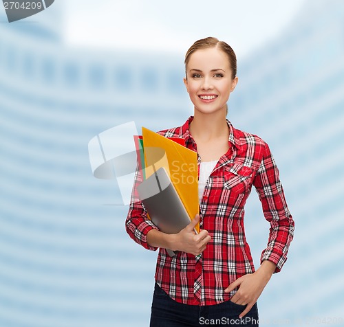 Image of smiling student with folders and tablet pc