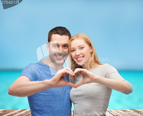 Image of smiling couple showing heart with hands