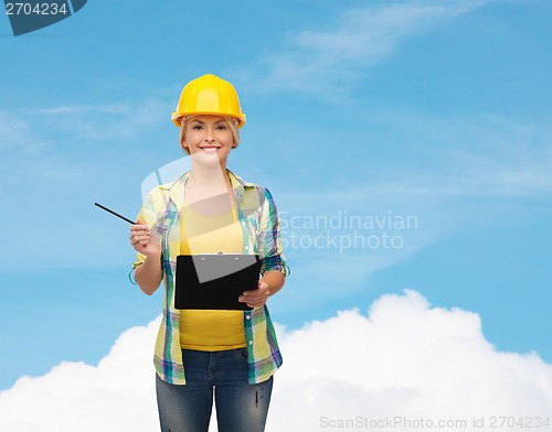 Image of smiling woman in helmet with clipboard