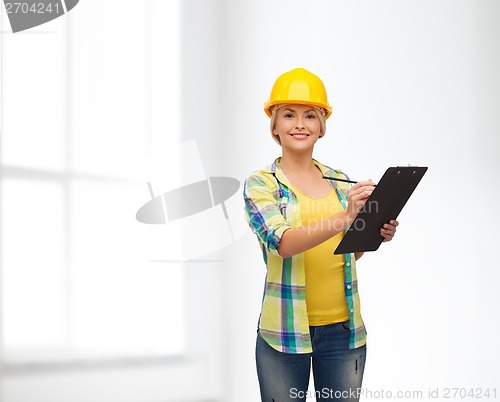 Image of smiling woman in helmet with clipboard