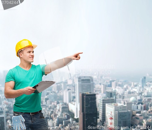 Image of smiling man in helmet with clipboard