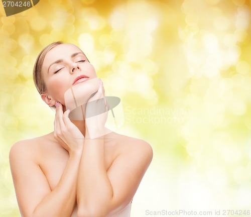 Image of beautiful woman touching her face with closed eyes