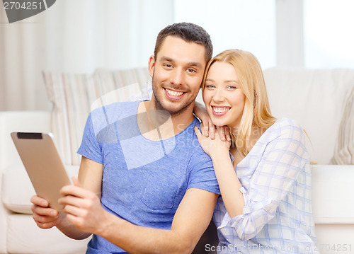 Image of smiling happy couple with tablet pc at home