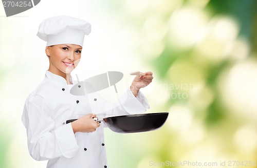 Image of smiling female chef with pan and spoon