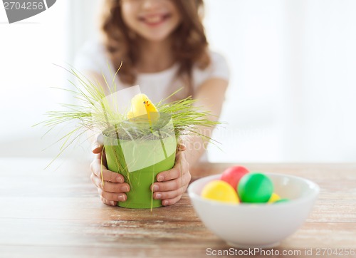 Image of close up of girl holding pot with green grass