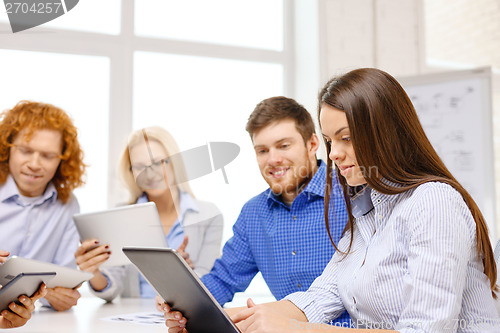 Image of smiling team with table pc and papers working